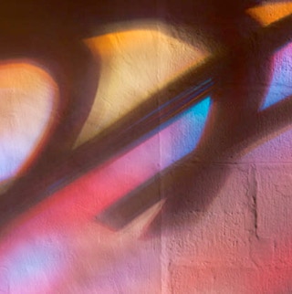 Buntes Lichtspiel an der Wand eines Sakralbaus